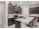 Beautiful kitchen with stainless steel appliances, dark cabinets, and an island with seating at 3852 E Bartlett Way, Chandler, AZ 85249