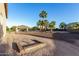 Wide view of a spacious yard with a covered patio, palm trees, and horseshoe pit, ideal for recreation at 3927 E Vista Grande --, San Tan Valley, AZ 85140
