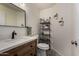 A modern half bathroom features a decorative mirror, wood vanity and patterned tile floors at 3927 E Vista Grande --, San Tan Valley, AZ 85140