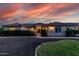 Stunning home with warm exterior lighting, manicured hedges, and beautiful stone accents during twilight at 3927 E Vista Grande --, San Tan Valley, AZ 85140