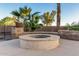 Comfortable outdoor fire pit area featuring stone accents and lush tropical landscaping, perfect for relaxing evenings at 3927 E Vista Grande --, San Tan Valley, AZ 85140