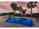Beautiful pool area with a stepped spa, poolside seating, and mature palm trees under a colorful sunset sky at 3927 E Vista Grande --, San Tan Valley, AZ 85140