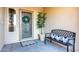 Inviting front porch with neutral tones, plants, a bench with decorative pillows, and a secure screen door at 3927 E Vista Grande --, San Tan Valley, AZ 85140