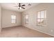 A bright bedroom features carpet, multiple windows, and a ceiling fan at 45071 W Portabello Rd, Maricopa, AZ 85139