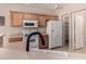 The kitchen is equipped with white appliances and light wood cabinets that provide ample storage at 45071 W Portabello Rd, Maricopa, AZ 85139
