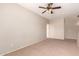 Spacious living room with neutral walls, ceiling fan, and an open doorway at 45071 W Portabello Rd, Maricopa, AZ 85139