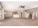 Open-concept living room that flows into the kitchen with neutral walls and large windows at 45071 W Portabello Rd, Maricopa, AZ 85139
