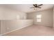 Large living room with a carpet floor and multiple windows, offering natural light at 45071 W Portabello Rd, Maricopa, AZ 85139