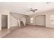 Open-concept living room features stairs, neutral walls, and large windows for natural light at 45071 W Portabello Rd, Maricopa, AZ 85139