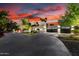 Stunning home exterior with manicured landscaping, a large circular driveway, and a three-car garage at sunset at 4835 E Onyx Ave, Paradise Valley, AZ 85253