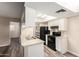 Kitchen with white cabinets, stainless sink, black appliances, pantry and wood-style flooring at 520 N Stapley Dr # 257, Mesa, AZ 85203