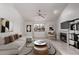 Bright living room featuring a white couch, fireplace, ceiling fan, and stylish decor at 533 W Guadalupe Rd # 2126, Mesa, AZ 85210