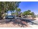 Neighborhood street view with tidy landscaping, mature trees, assigned covered parking and various parked vehicles at 533 W Guadalupe Rd # 2126, Mesa, AZ 85210