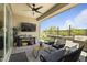 Cozy covered patio with comfortable seating, a ceiling fan, an outdoor television, and a view of the landscaped backyard at 5871 N 187Th Ln, Litchfield Park, AZ 85340