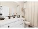 Bathroom features a white vanity, dark hardware, a shower with curtain and neutral colored walls at 5871 N 187Th Ln, Litchfield Park, AZ 85340