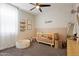 Charming Bedroom with a crib, shelving, and a cozy play area with plush carpet at 5871 N 187Th Ln, Litchfield Park, AZ 85340