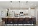 Modern kitchen features white cabinets, a large quartz countertop island, and pendant lighting above barstool seating at 5871 N 187Th Ln, Litchfield Park, AZ 85340