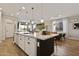 Spacious kitchen island features a sink, white cabinets and countertops, and modern pendant lighting at 5871 N 187Th Ln, Litchfield Park, AZ 85340