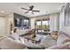 Cozy living room features a large sectional sofa, a ceiling fan, and sliding glass doors to the outdoor patio at 5871 N 187Th Ln, Litchfield Park, AZ 85340