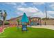 Backyard featuring an outdoor dining area, artificial grass, and a covered lounge at 5940 W Robinson Way, Chandler, AZ 85226