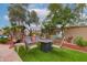 Backyard featuring patio seating, artificial grass, mature trees, and a fire pit at 5940 W Robinson Way, Chandler, AZ 85226