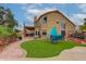 Expansive backyard featuring artificial turf, outdoor kitchen, seating area, and lush landscaping at 5940 W Robinson Way, Chandler, AZ 85226