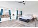 Spacious bedroom with blue curtains, lots of light, vaulted ceiling and a plush upholstered king bed at 5940 W Robinson Way, Chandler, AZ 85226