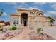 Inviting tan home featuring a three-car garage, arched entryway, and well manicured front yard landscaping at 5940 W Robinson Way, Chandler, AZ 85226