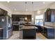 Modern kitchen featuring stainless steel appliances, dark cabinetry, granite countertops and tiled backsplash at 5940 W Robinson Way, Chandler, AZ 85226
