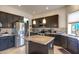 Modern kitchen featuring stainless steel appliances, dark cabinetry, granite countertops and tiled backsplash at 5940 W Robinson Way, Chandler, AZ 85226
