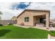 Backyard featuring artificial grass and landscaped patio with a hot tub and covered seating area at 607 W Tenia Trl, San Tan Valley, AZ 85140