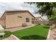 Backyard featuring artificial turf, stone landscaping, and a covered patio with a hot tub at 607 W Tenia Trl, San Tan Valley, AZ 85140