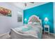 A modern bedroom showcases a striking blue accent wall, ceiling fan, and bedside lamps at 607 W Tenia Trl, San Tan Valley, AZ 85140