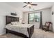 A cozy bedroom offers natural light with a ceiling fan, area rug, and rocking chair at 607 W Tenia Trl, San Tan Valley, AZ 85140