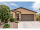 Charming single-story home featuring a well-manicured landscape, stone accents, and a two-car garage at 607 W Tenia Trl, San Tan Valley, AZ 85140