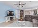 Comfortable living room featuring a large TV, a cozy sofa, and an open layout to the dining area at 607 W Tenia Trl, San Tan Valley, AZ 85140