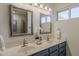 Updated bathroom features a double sink vanity, updated lighting, and a framed mirror at 656 W Devon Ct, Gilbert, AZ 85233