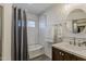 Comfortable bathroom featuring a wood vanity, sink, gray shower curtain, and tiled shower surround at 656 W Devon Ct, Gilbert, AZ 85233