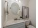 Clean half bathroom with a round mirror, decorative artwork, and white fixtures at 656 W Devon Ct, Gilbert, AZ 85233
