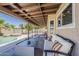 Inviting covered patio with comfortable seating overlooks the pool and lush backyard at 656 W Devon Ct, Gilbert, AZ 85233