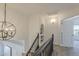 Bright upstairs hallway featuring a decorative chandelier, hallway niche, and open doorway to an adjoining room at 656 W Devon Ct, Gilbert, AZ 85233