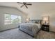 Comfortable main bedroom with neutral tones, large window overlooking neighborhood and ceiling fan at 656 W Devon Ct, Gilbert, AZ 85233