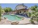 Lush backyard with a lagoon style pool, covered patio, and well-manicured landscaping at 656 W Devon Ct, Gilbert, AZ 85233