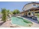 Backyard showcasing a sparkling pool, rock features, lush landscaping, and covered patio at 656 W Devon Ct, Gilbert, AZ 85233