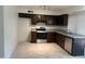 Bright kitchen featuring tile floors, stainless steel appliances, and dark wood cabinets at 6605 N 46Th Ln, Glendale, AZ 85301