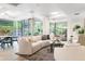Bright living room with a curved sofa and floor-to-ceiling windows overlooking a garden at 7117 E Rancho Vista Dr # 1012, Scottsdale, AZ 85251