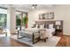 Bright main bedroom features a hardwood floor, tufted headboard and a sitting area at 7117 E Rancho Vista Dr # 1012, Scottsdale, AZ 85251