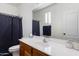 Bathroom with wood vanity, framed mirror, and shower with patterned curtain at 7305 W Darrel Rd, Laveen, AZ 85339