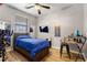 Bedroom featuring wood floors, desk, mounted TV, and ceiling fan at 7305 W Darrel Rd, Laveen, AZ 85339