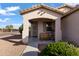 Charming covered front porch with a cozy bench and decorative plants at 7305 W Darrel Rd, Laveen, AZ 85339